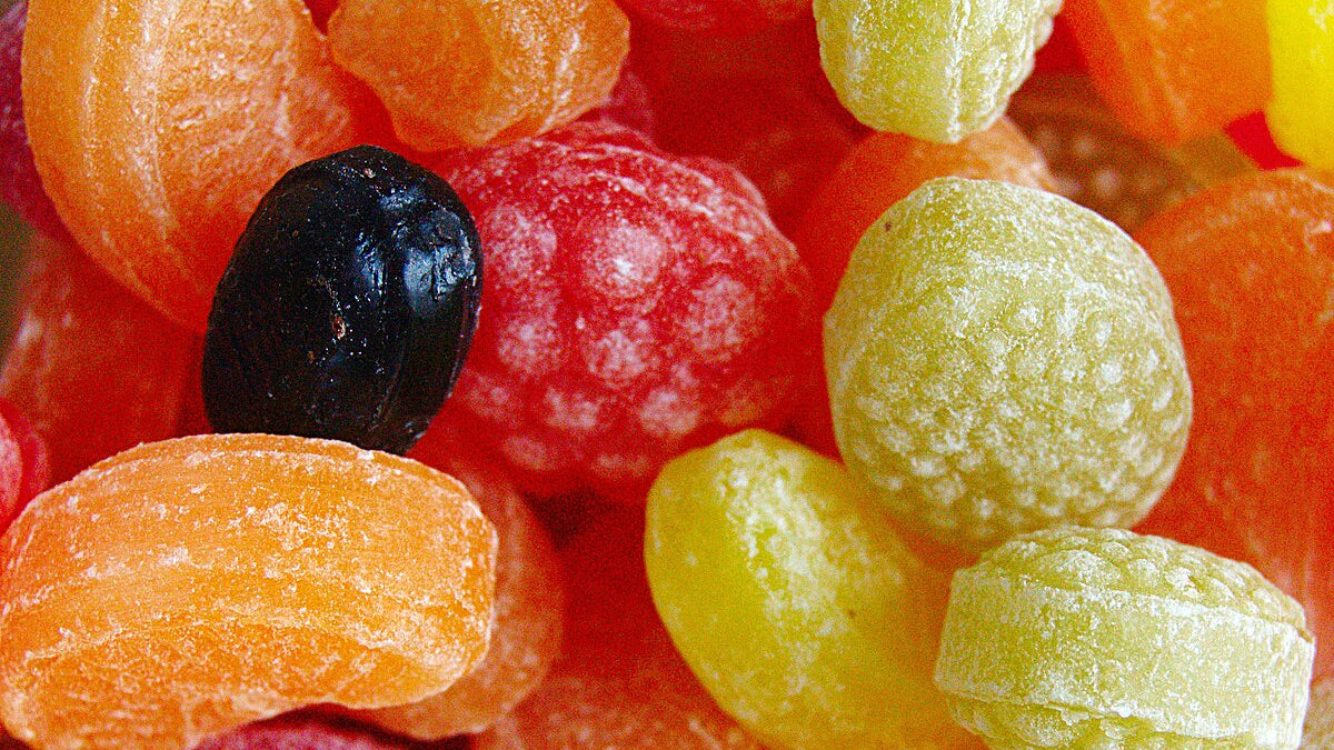 Assorted colorful gummy candies including black, red, green, and orange.