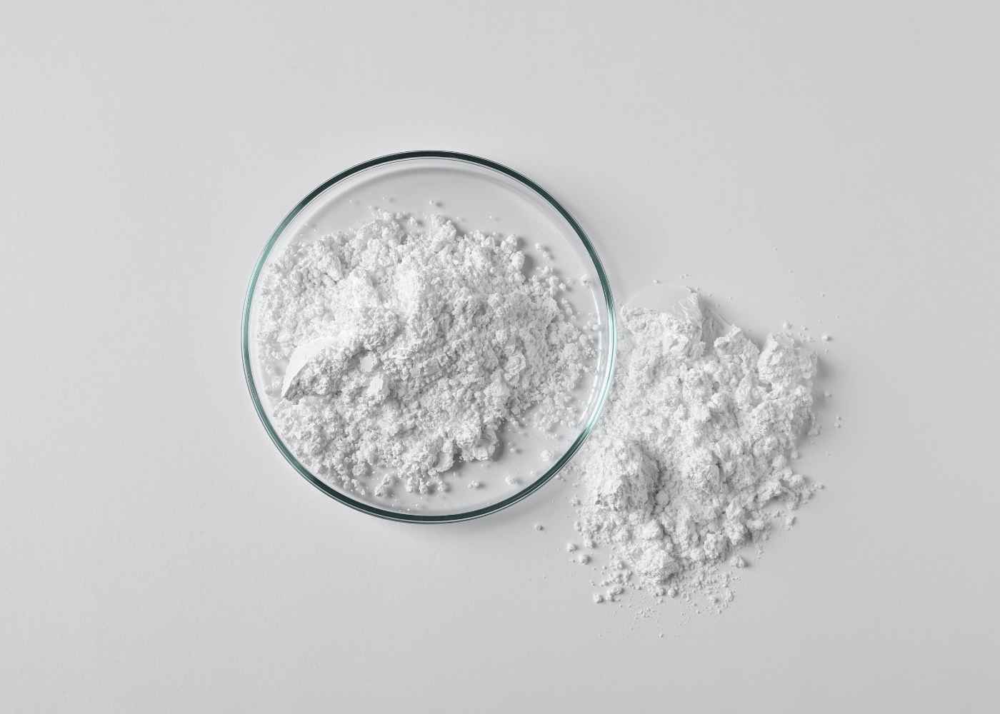 White powder in a glass bowl on a light gray background