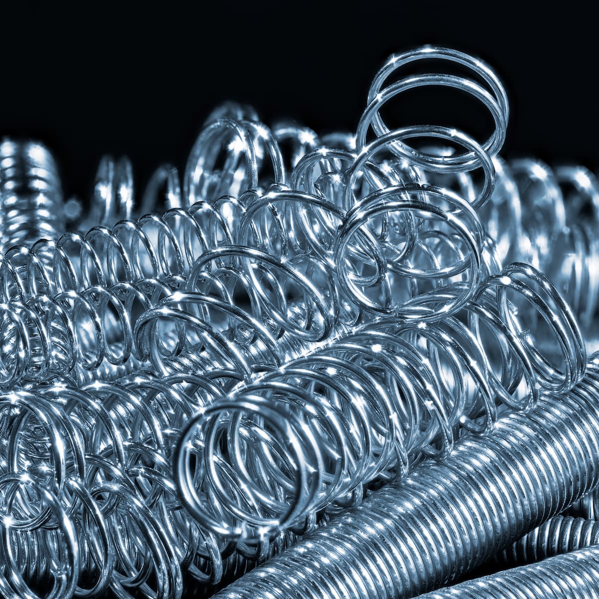 Stack of metal springs on a black background