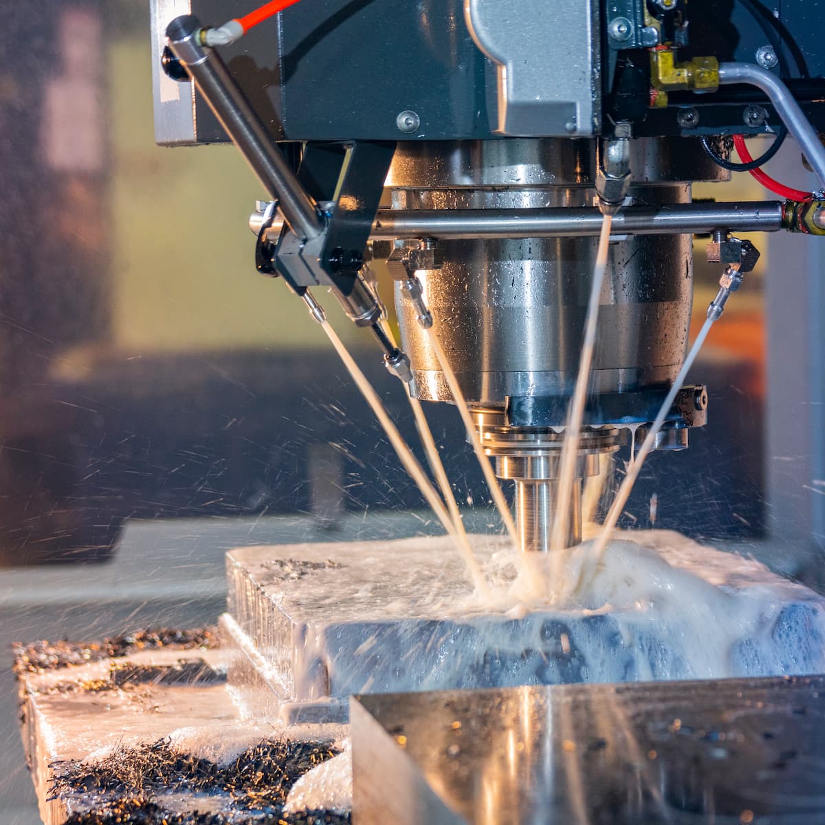CNC machine cutting metal with water spray in a workshop setting