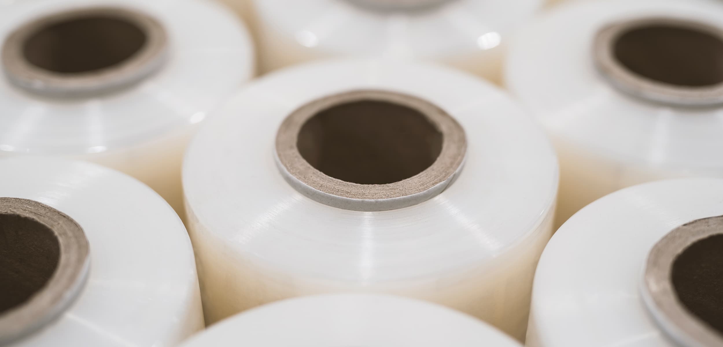Close-up of white spools with central holes on a light background
