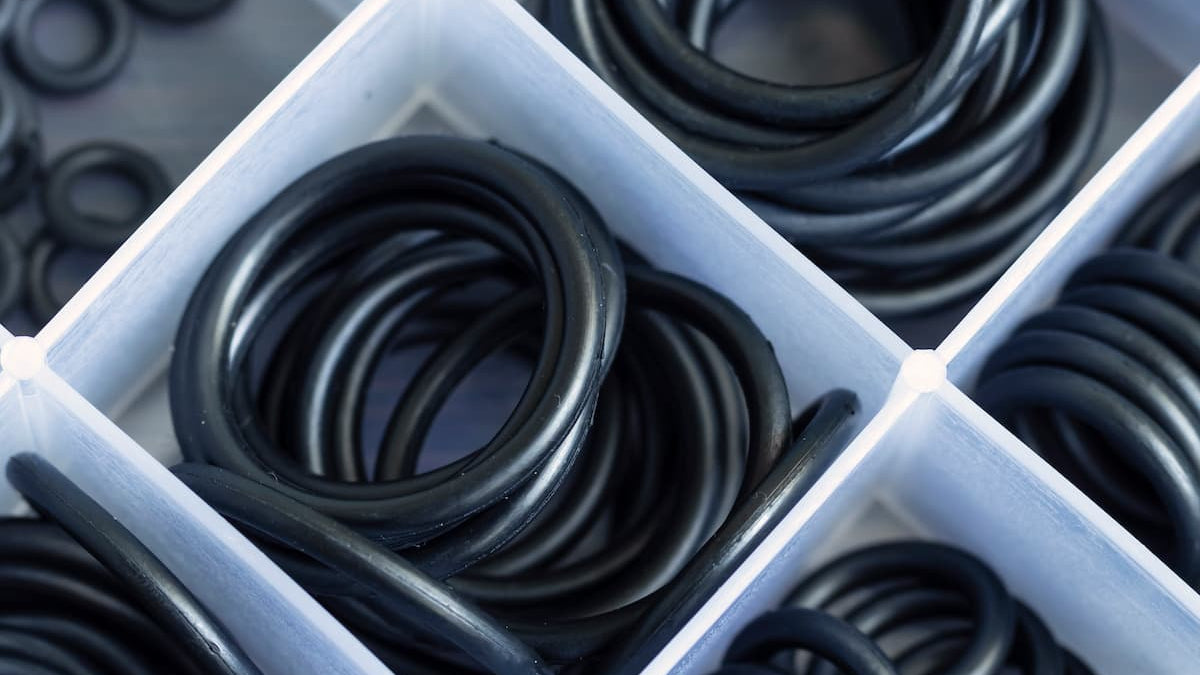 Set of black rubber gaskets in a white container