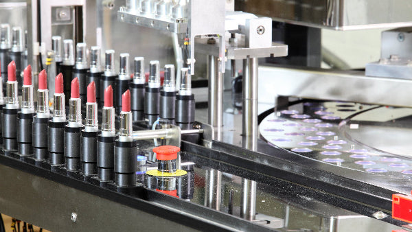 Row of lipsticks on an assembly line in a manufacturing setting
