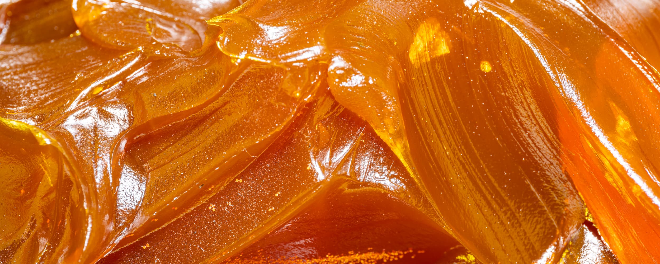 Close-up of amber-colored gelatinous substance with a glossy texture.