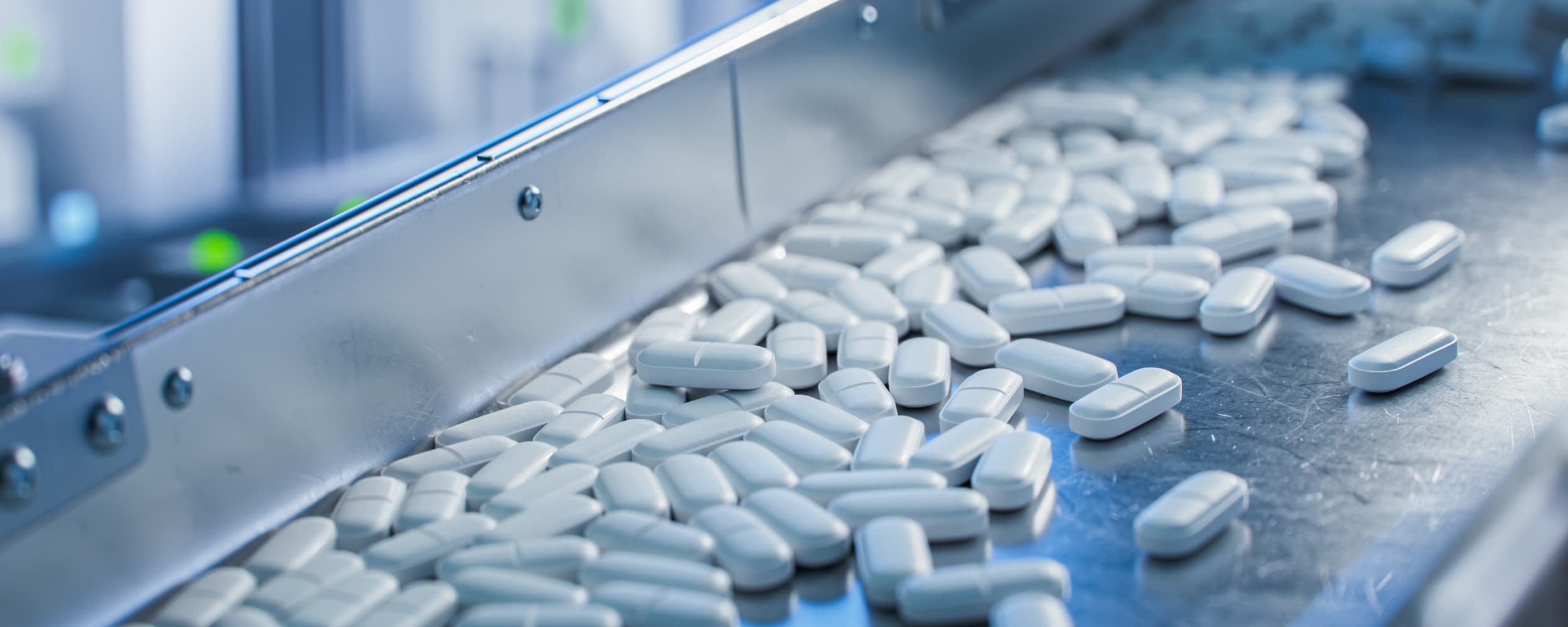 Pill production line with white pills on a conveyor belt