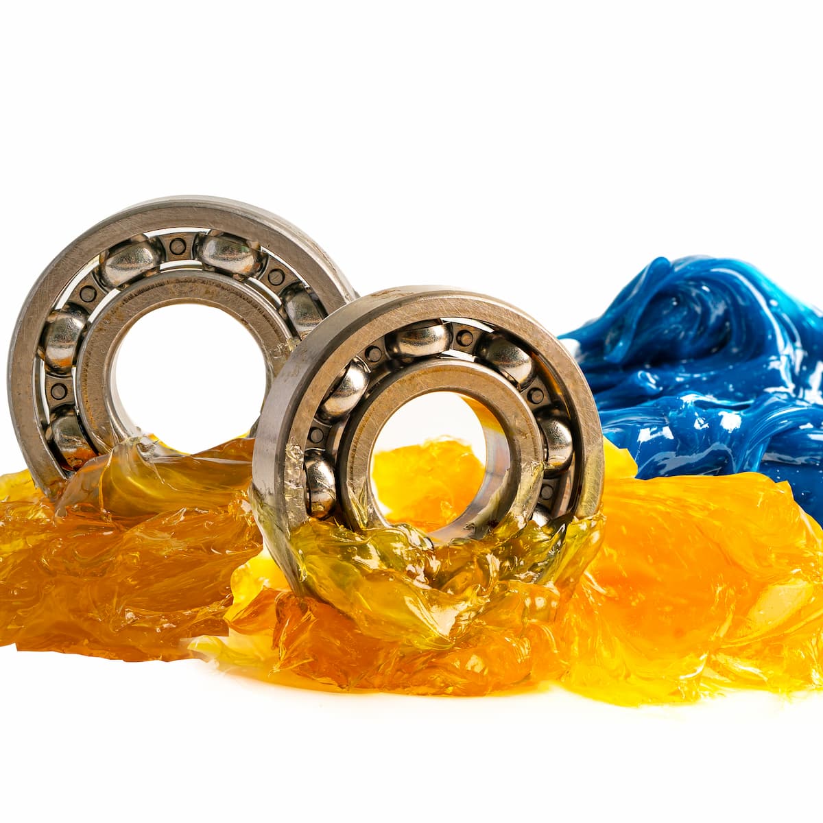 Two metal bearings surrounded by yellow and blue plastic-like material on a white background